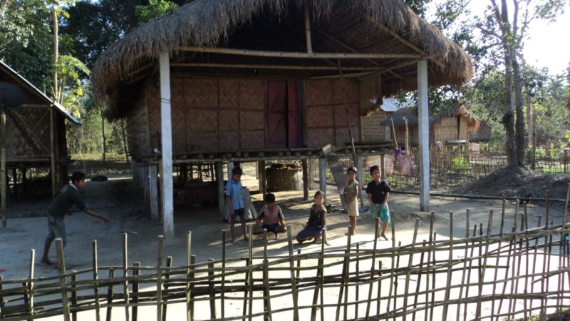 IM Dorf gibt es nur Bambushläuser. Die Kinder spielen mit farbigen Steinchen die sie im Sand finden. . 