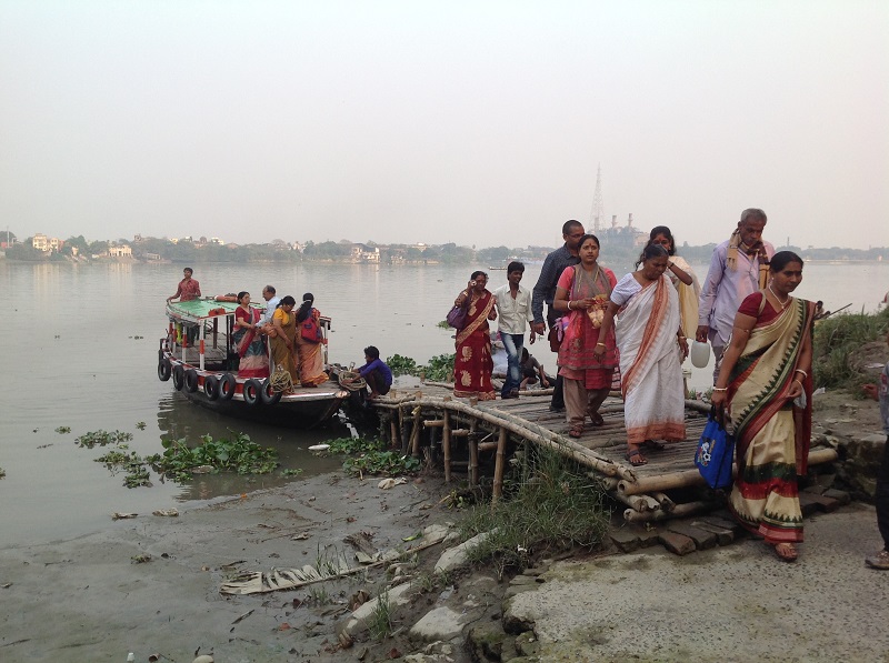 Eine Reisegesellschaft setzt über den Ganges. Wunderbare Saris. 